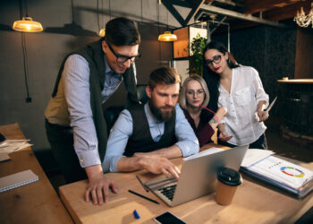 Talks. Colleagues working together in modern office using devices and gadgets during creative meeting. Discussing, making decisions, routine tasks, projects. Successful corporate teamwork.